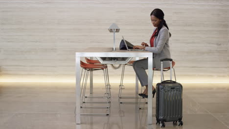 hermosa mujer de negocios afroamericana inteligente trabajando en una computadora portátil en el vestíbulo