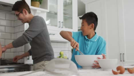 웃는 아들과 딸과 함께 아침 식사를 하는 부 ⁇ 에 있는 행복한 아시아인 아버지