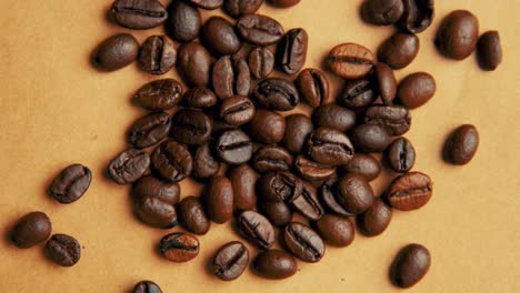 Coffee-beans-on-old-paper-rotating-4K-close-up-video-from-top