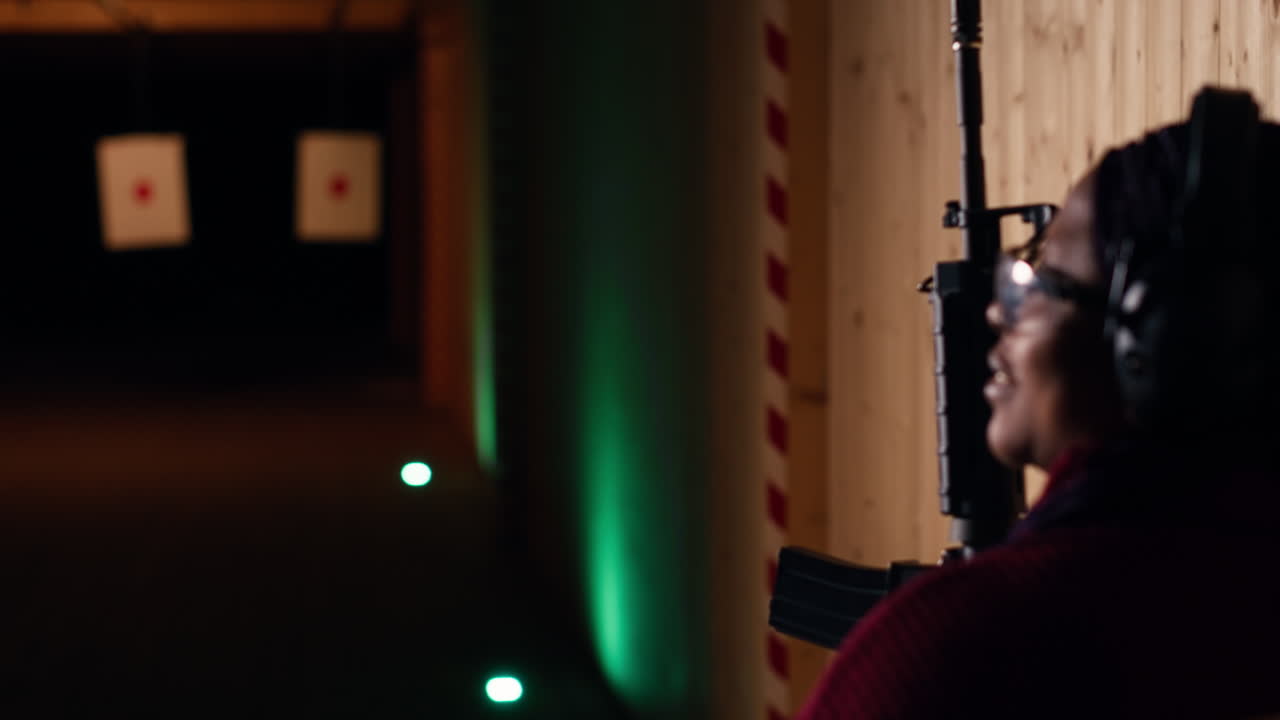 권총을 들고 사격장에서 훈련하는 여자, 종이 표적에 대한 결과를 보고