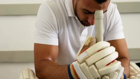 Cricketspieler-Sitzt-Auf-Der-Bank-In-Der-Umkleidekabine