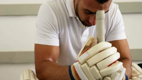 cricket player sitting on bench in dressing room