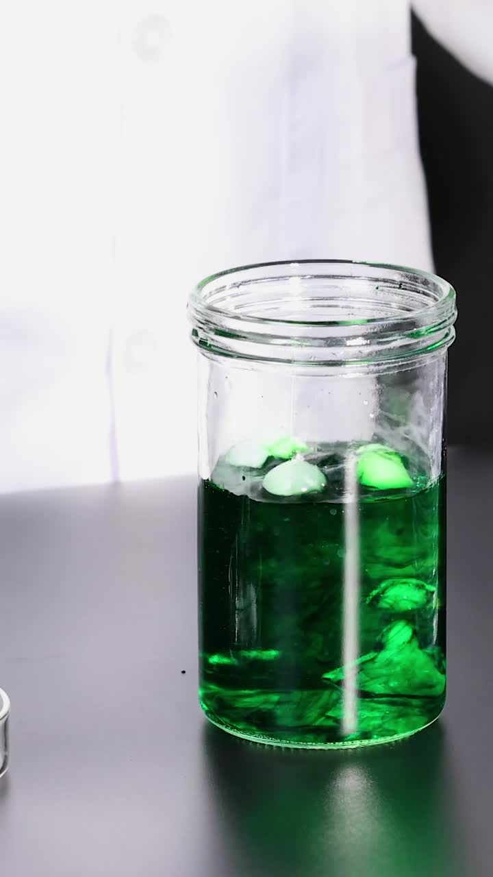 el hielo seco reacciona en líquido verde, produciendo humo.