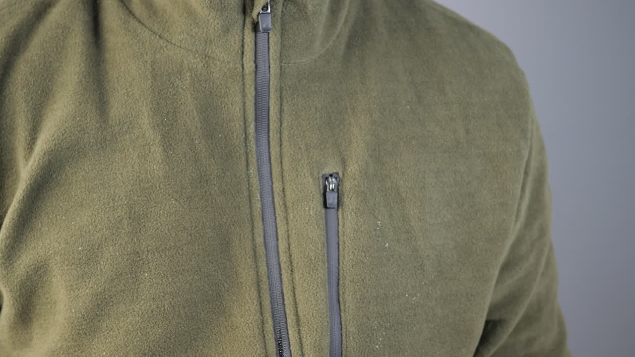 Man Adjusting Zip on Olive Green Fleece Jacket