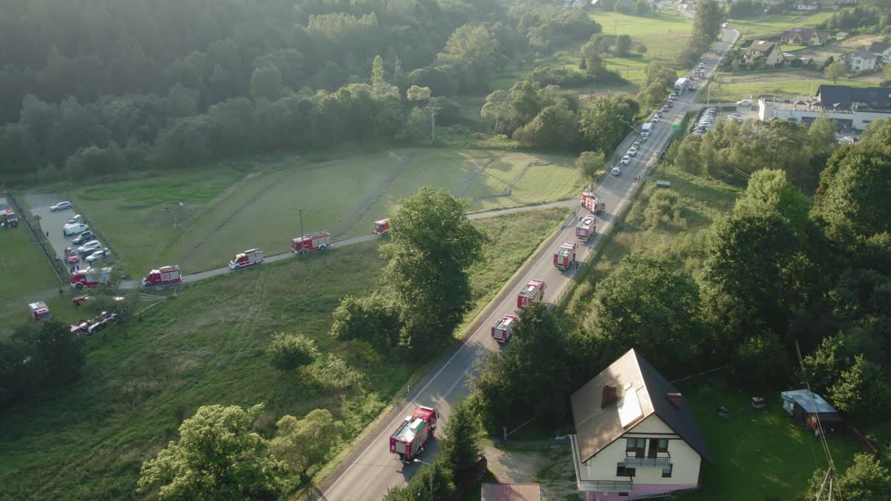 해가 지는 동안 도로에서 소방차 퍼레이드의 공중 뷰 4k