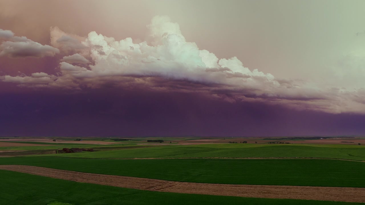Moln i solnedgångsfärger över ett vackert jordbrukslandskap, 4k-drönarfilm från luften.