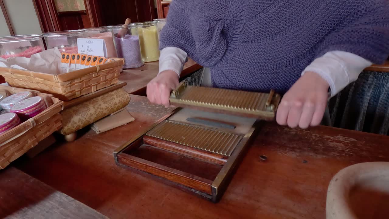 Hands crafting candy using traditional tools