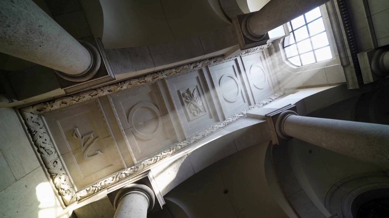 Tilting handheld camera in nave, revealing frieze as sunlight shifting across columns