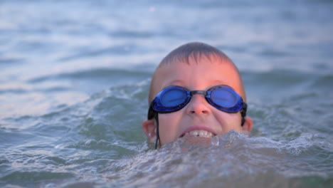 cheerful boy in goggles bathing in the sea