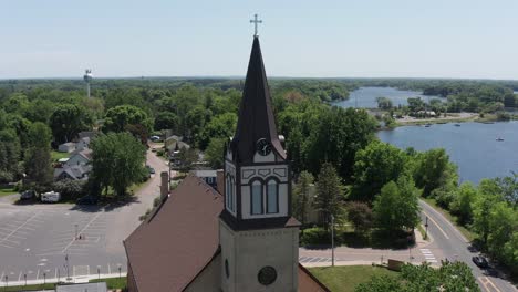 Close-up-panning-aerial-shot-of-the-spire-atop-a-Lutheran-Church-on-the-lake-in-Center-City,-Minnesota