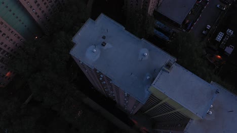 Aerial-footage-looks-down-over-housing-project-highrise-buildings-in-Harlem,-NYC-in-early-morning