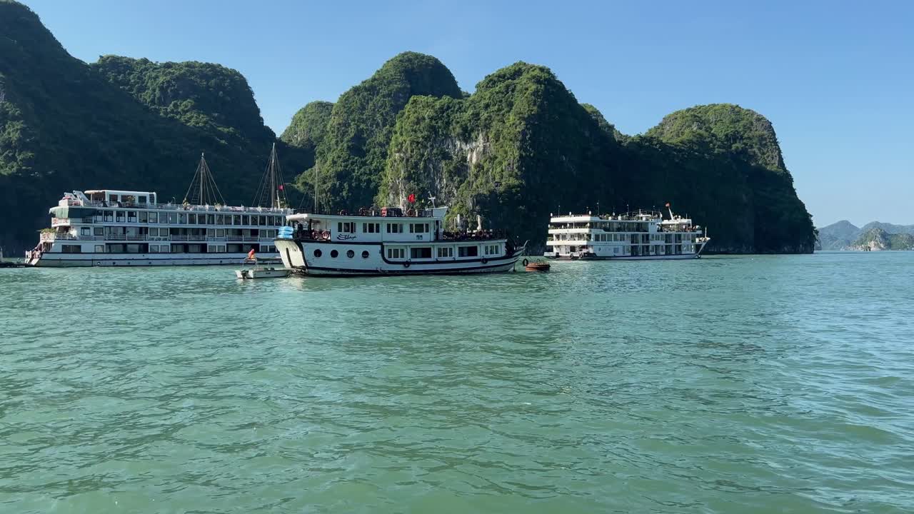 botes chatarra navegando entre formaciones rocosas en la bahía de halong en un día soleado