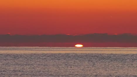 Amanecer-En-El-Océano,-El-Sol-Comienza-A-Elevarse-Sobre-El-Mar-En-Calma