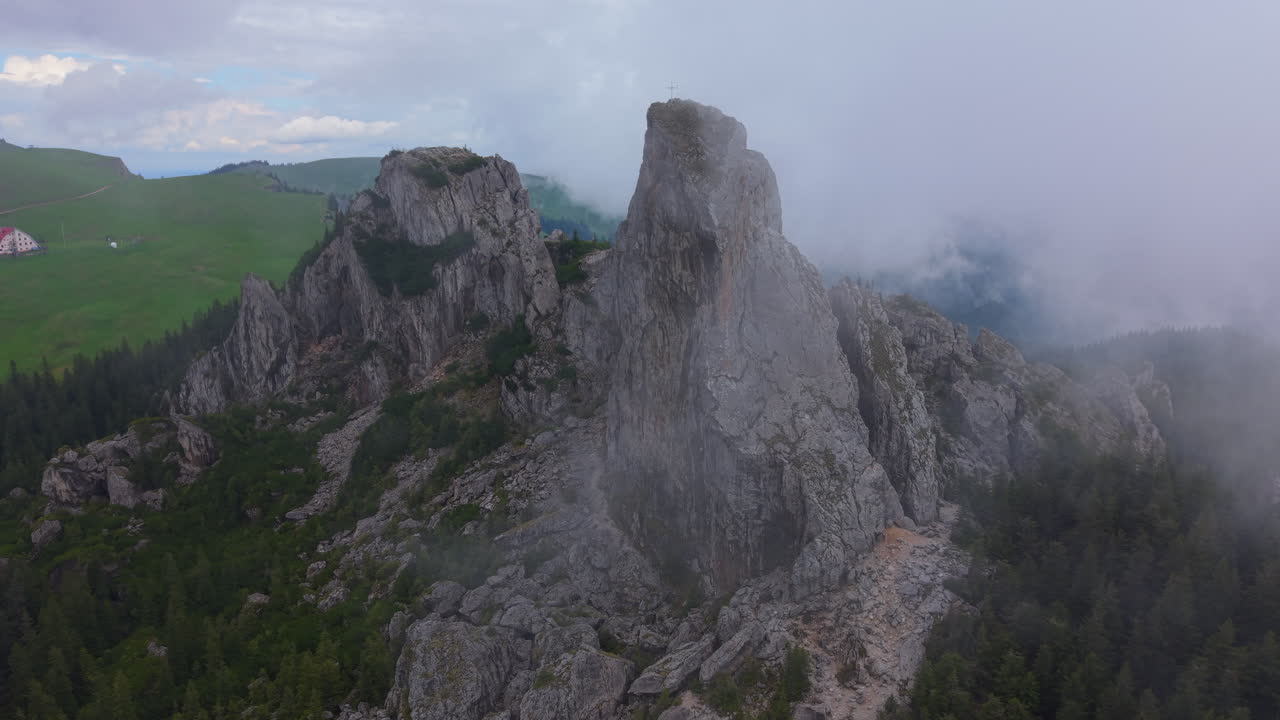 Aerial view of clouds moving around Pietrele Doamnei rock formations in Rarau Mountains, Romania