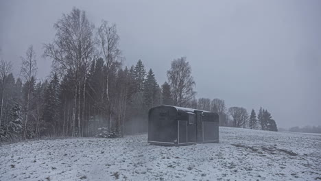 time lapse of steel cabin or small house in the middle of snowfall