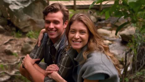 happy hiker couple sitting near the river