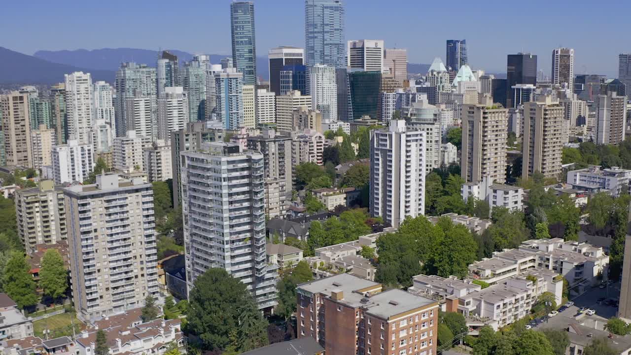Aerial panramic downtown Vancouver in a sunny cityscape  birds eye view of foliage parks condos hotels, apartments, and commercial buildings.