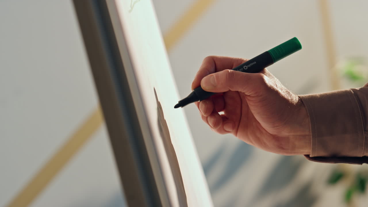 컨퍼런스에서 화이트보드 위에 손으로 글을 쓰는 사람. 관리자가 프레젠테이션을 그립니다.