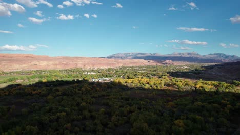 rising drone shot of downtown moab, utah in the fall on a sunny day