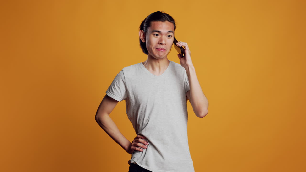 Modern asian man answering telephone call on camera