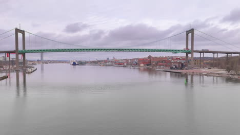 Wide-aerial-tracking-shot-of-Älvsborg-bridge-spanning-Göta-Älv-river,-Gothenburg