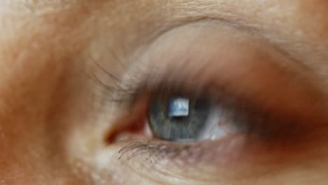 close up of female eye looking at tablet