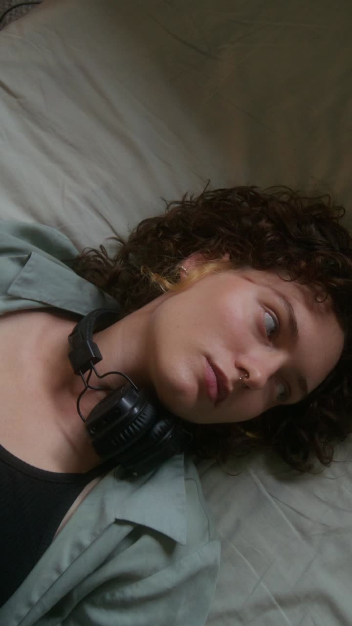 mujer relajándose en la cama con auriculares