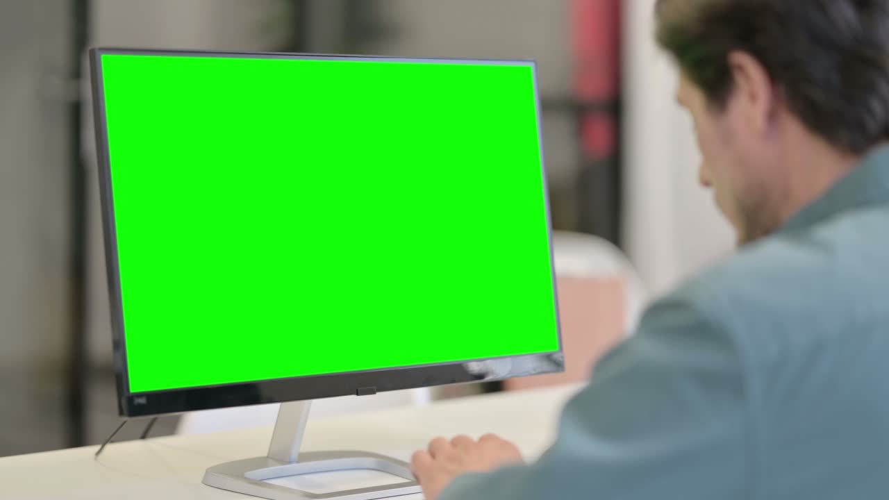 녹색 크로마 키 스크린을 가진 데스크을 사용하는 사람