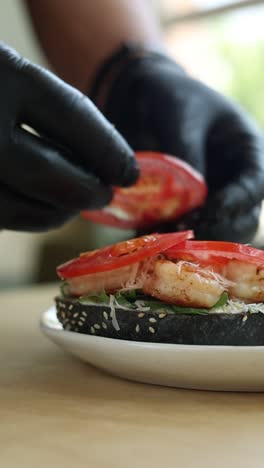 chef preparing a delicious shrimp and tomato sandwich