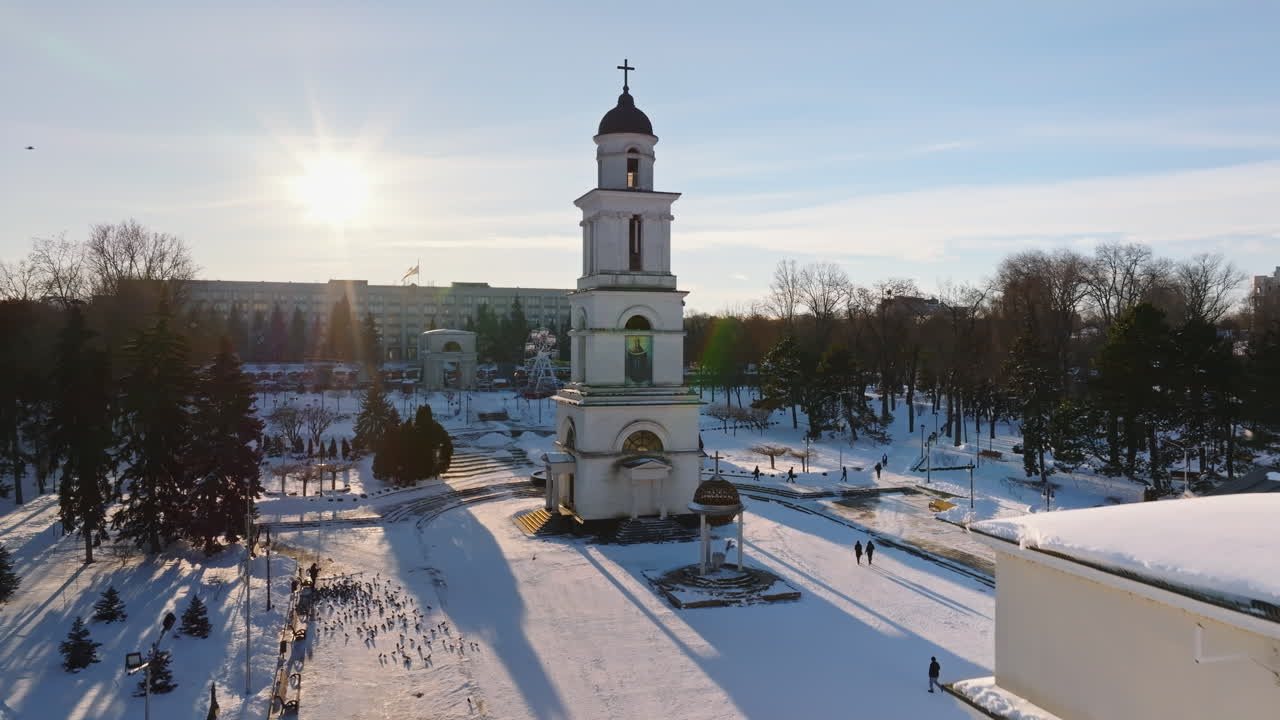 Aerial drone view of the Bell tower of the Metropolitan Cathedral of Christ's Nativity. City center covered in snow at sunset in Chisinau, Moldova