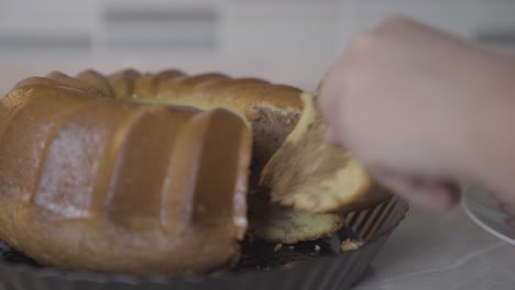 slicing marble bundt cake with knife on plate