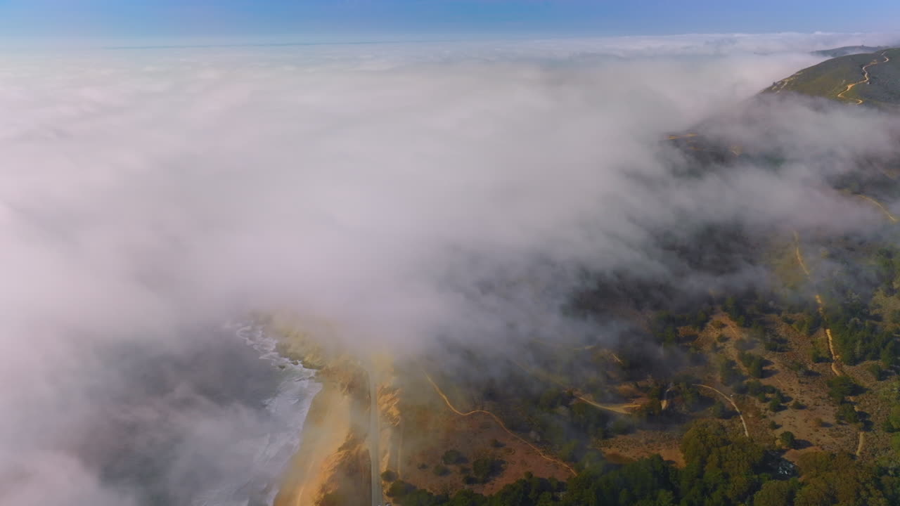 Pacific coastline covered with thick white fog. Rocky beach of Montara, California, USA. Aerial view.