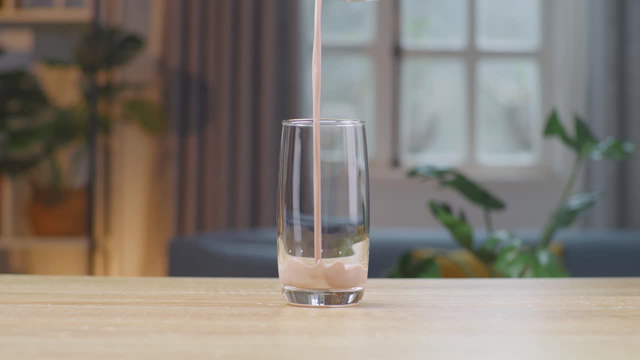 천천히 움직이는 초콜릿 우유 음료를 잔에 부어