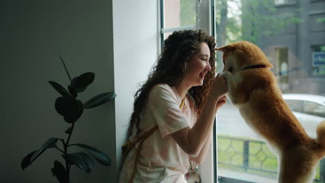 woman and her akita dog by the window