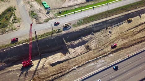 orbita aérea estrecha alrededor de grúa, excavadora y camiones de descarga en un sitio de construcción en lehi utah