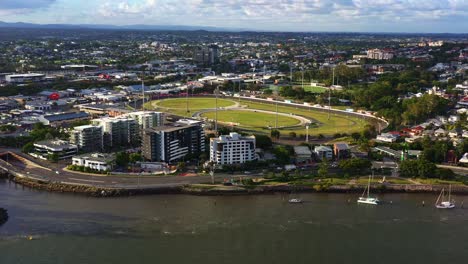 aerial fly around capturing brisbane city metropolitan racecourse, albion park paceway, the creek harness racing club located next to breakfast creek at sunset, queensland, australia