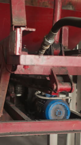 air pumps installed on red metal rack with rubber pipes in mechanical room. electrical compressors work at heat generating and distribution station