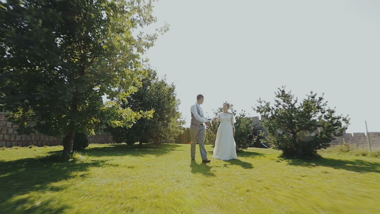 Wedding couple running around an old castle. Walking in the open air