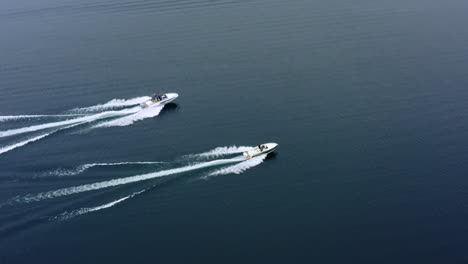 flying away shot of speed boats sailing on lake along each other