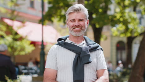 portrait of happy bearded mature man smiling friendly glad expression looking at camera relaxation