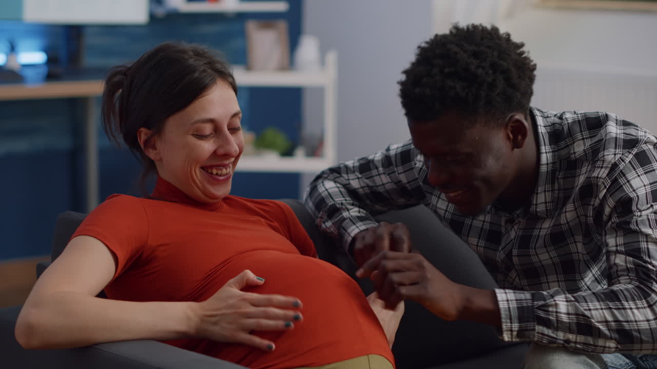 Close up of interracial couple with pregnancy at home