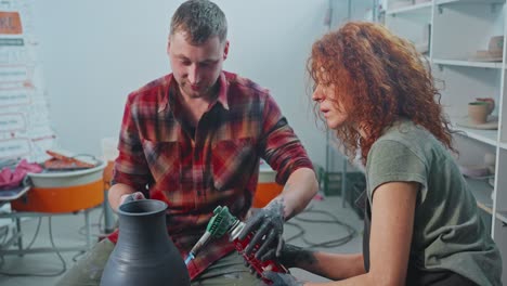 two potters working on a pottery piece