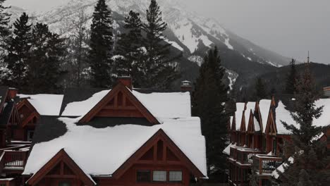 wooden house rooftops covered in snow after snowfall, foggy mountain background