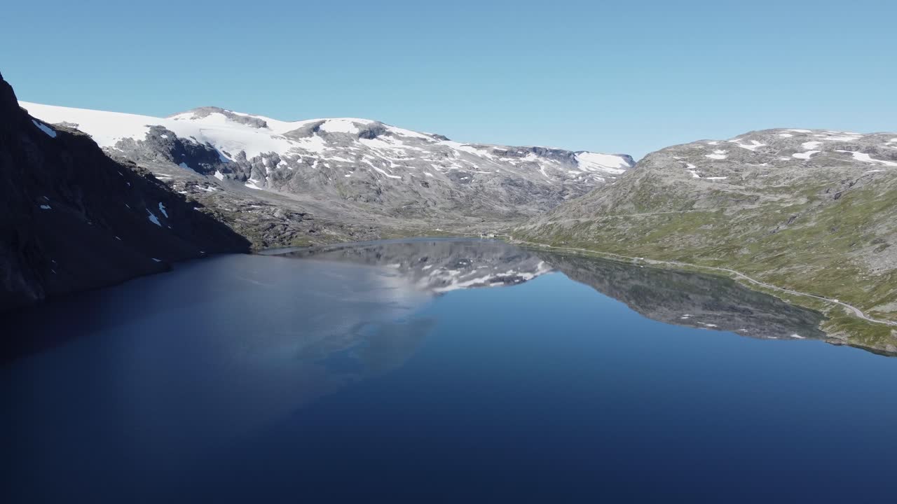 lago en la comuna de rauma de noruega, con montañas cubiertas de nieve en el fondo