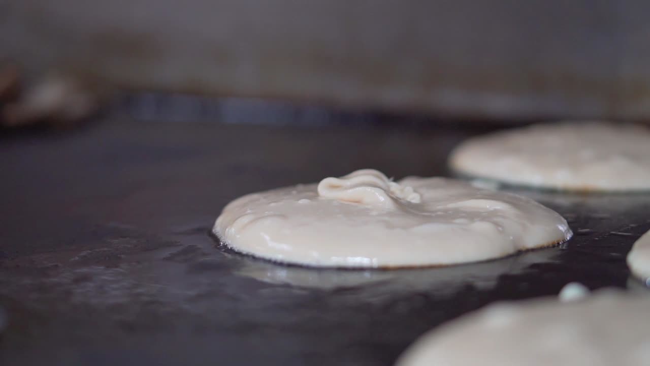 Pouring thick sticky pancake mix onto grill