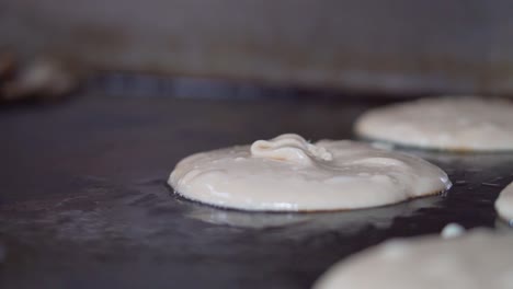 pouring thick sticky pancake mix onto grill