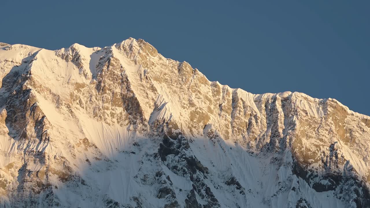 Snowcapped Mountain Top Close Up with Blue Sky in Nepal, a Popular Trekking and Hiking Route in Nepal with Snowy Mountains in Snow in Last Light at Dusk in Himalayas in Nepal in Annapurna Region