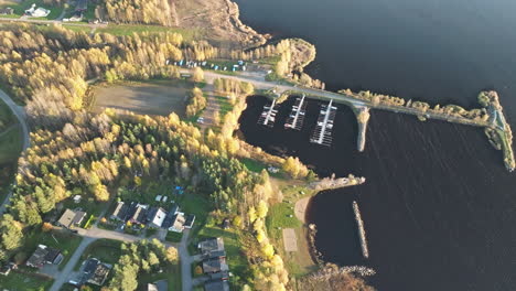 Pueblo-Residencial-Y-Puerto-Deportivo-Con-Colores-Otoñales-Junto-Al-Lago-Al-Atardecer-En-Suecia