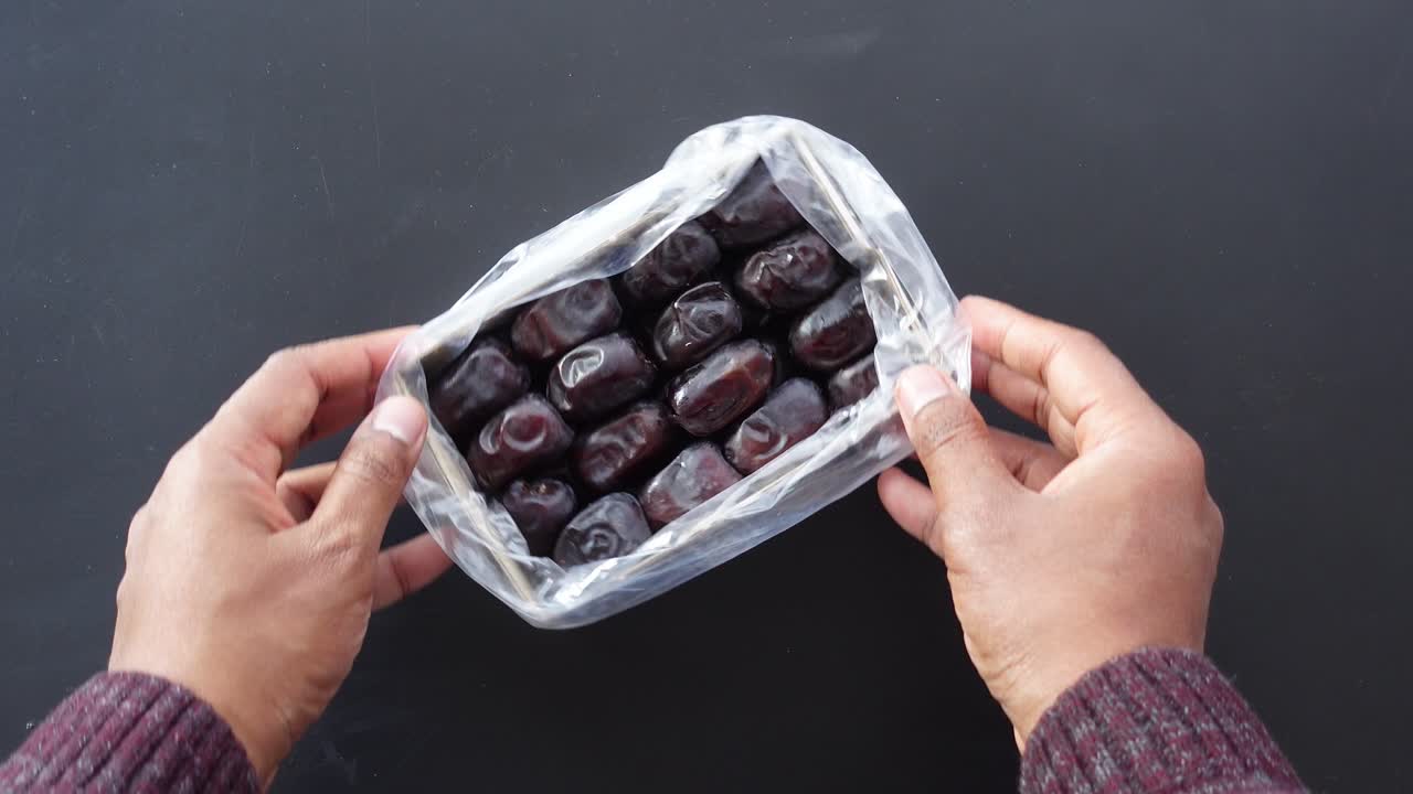 Hands holding a box of dates
