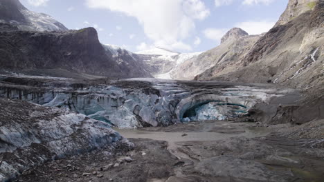 Panoramablick-Auf-Die-Schmelzende-Eishöhle-Des-Pasterze-Gletschers-Aufgrund-Des-Klimawandels,-Sich-Zurückziehender-Gletscher-Der-österreichischen-Alpen,-Bedeckt-Mit-Trümmern-Im-Unteren-Teil-Des-Großglockners,-Nahaufnahme-Aus-Der-Luft